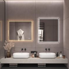 a bathroom with two sinks and a large mirror above the sinks is illuminated by lights