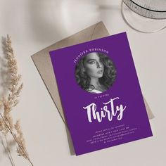 a purple card with the words thirty on it and a glass of water next to it