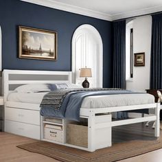 a bedroom with blue walls and white furniture