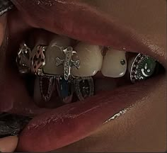 a close up of a person's mouth with many rings on it, including cross