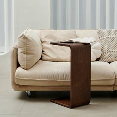 a couch with a book on top of it next to a table that is sitting on the floor