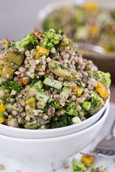 a white bowl filled with broccoli and other food on top of a table