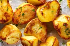 cooked potatoes with herbs and seasoning sitting on a piece of parchment paper, ready to be eaten