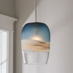 a glass light fixture hanging from a ceiling in a room with white walls and windows