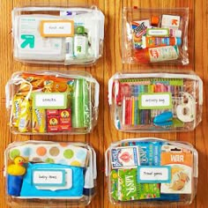 plastic containers filled with different types of school supplies on a wooden table in front of a wall