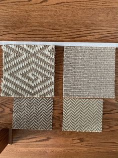 three samples of woven fabric on a wooden surface, one in grey and the other in white