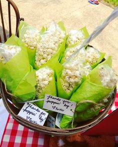 a basket filled with lots of food on top of a red and white checkered table cloth