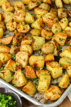 roasted potatoes with herbs and seasoning in a baking pan