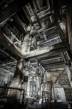 the inside of an industrial building with stairs and railings