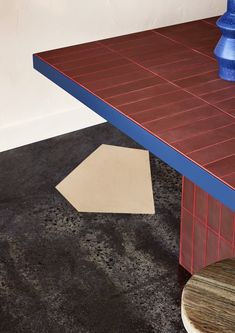 a blue vase sitting on top of a wooden table next to a white and brown rug