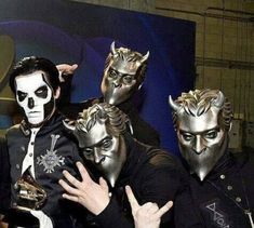 four men in masks posing for the camera