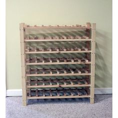 a wooden rack with several rows of empty wine bottles on it's sides, in front of a wall