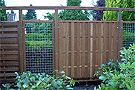 the fence is made of wood and has plants growing on it