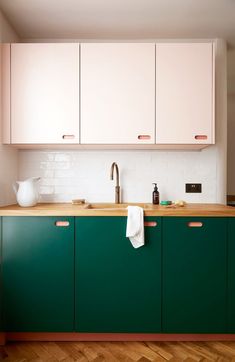 a kitchen with green cabinets and wooden floors