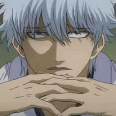 a man with white hair and blue eyes is looking at the camera while holding his hands to his chest