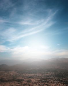 the sun is shining brightly through the clouds in the sky over some hills and desert