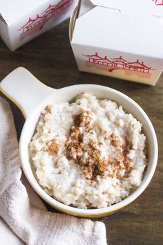 a bowl of mashed potatoes with cinnamon on top next to a box of milk