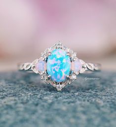 an opal and diamond ring on top of a table