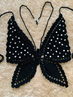 a crocheted black and white butterfly with polka dots on it's wings