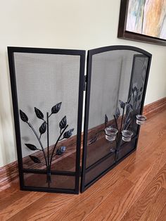 two decorative fireplace screens sitting on top of a hard wood floor