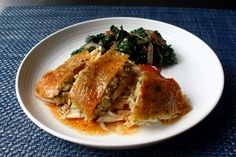 a white plate topped with meat and veggies on top of a blue place mat