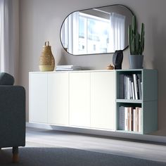 a living room with a large mirror on the wall and bookshelf in front of it