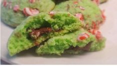 green and red cookies on a plate with sprinkles in the middle one is half eaten