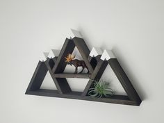 a wooden shelf with an animal and some plants on it