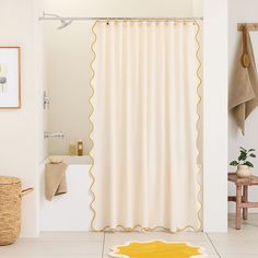 a bathroom with a yellow rug on the floor next to a bathtub and shower curtain