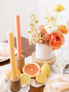 the table is set with oranges, lemons and candles