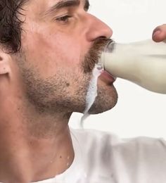 a man drinking milk from a bottle