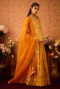 Step into refined elegance with the gold yellow appliqué silk brocade choli kurta, beautifully paired with a multi-panel brocade lehenga. This stunning ensemble showcases intricate appliqué detailing that enhances the luxurious brocade fabric, while the flowing lehenga offers a beautiful silhouette. Complemented by an embroidered dupatta, this outfit is perfect for festive occasions, blending traditional charm with modern sophistication. Gold Brocade Designer Dresses, Gold Brocade Dresses For Designer Wear, Designer Brocade Gold Dresses, Designer Gold Brocade Dresses, Designer Gold Georgette Salwar Kameez, Designer Gold Georgette Dresses, Gold Sharara In Raw Silk With Intricate Embroidery, Gold Intricate Embroidered Raw Silk Sharara, Gold Raw Silk Sharara With Intricate Embroidery