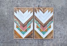 two pieces of art made out of wood with different colors and shapes on the wall