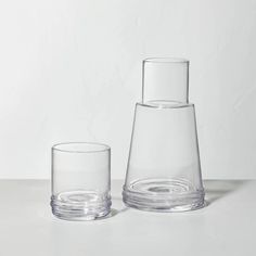 two clear glass vases sitting next to each other