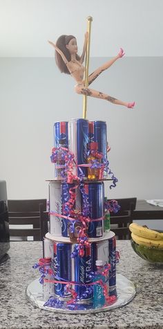 there is a cake made to look like a barbie doll on top of soda cans