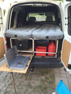 the back end of a white van with its doors open