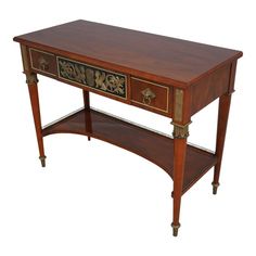 a wooden table with two drawers on one side and an ornate design on the other