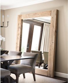 a dining room table with chairs and a large mirror