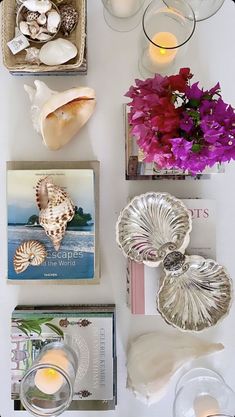 the table is set with candles, seashells and flowers