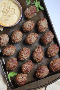 meatballs on a baking sheet with dip in the middle