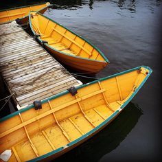 two yellow boats tied to a dock in the water