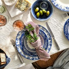 a table set with plates, silverware and napkins for two people to eat