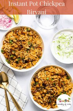 three bowls filled with food on top of a white table next to silver spoons