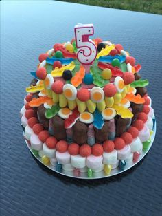 a birthday cake that is decorated with candy and candies on top of it, sitting on a table