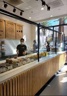 a man standing behind a counter with food on it