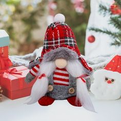 there is a small christmas gnome next to other ornaments and gifts on the table,