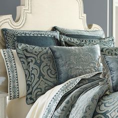 a bed covered in blue and white comforters