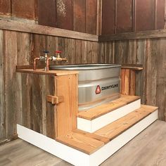 a stainless steel tank sitting on top of wooden steps