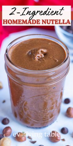 two ingredient homemade nutella in a glass jar with nuts around it and the text overlay reads, 2 ingredient homemade nutella