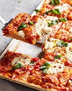 a close up of a slice of pizza on a pan with a spatula in it